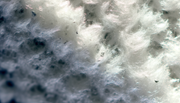 Close-up of mineral wool insulation material with water droplets, showcasing its hydrophobic nature and resistance to moisture.