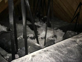 Snow-covered ground seen through metal railings, highlighting insulation materials context.