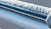 Frozen metal pipe covered in frost illustrating the importance of pipe insulation for energy efficiency.