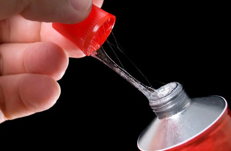 Bottle of red adhesive being applied for effective pipe insulation installation techniques